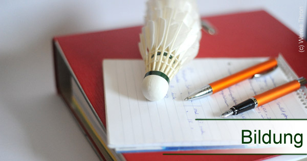 Auf dem Bild sind ein Ordner, Stifte, Federbälle, ein Notizbock und der Schriftzug Bildung zu sehen.